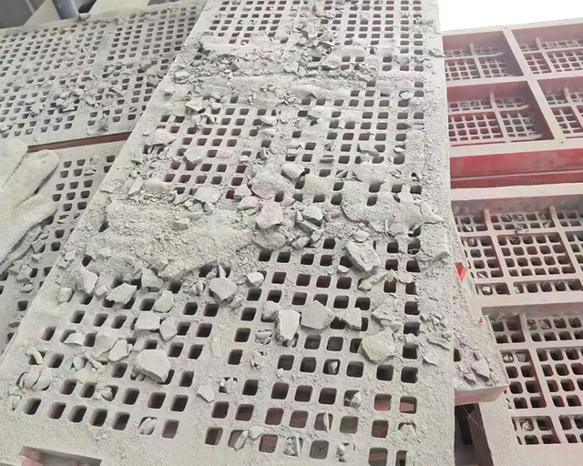 Close-up view of aggregate screen panel blocked with materials, demonstrating the need for efficient solutions to prevent downtime.